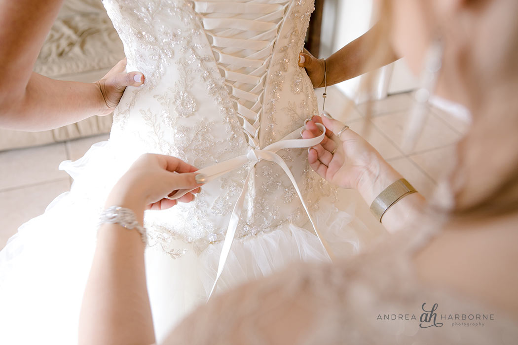 Getting Ready photo of bridesmaids helping bride tie dress Tips for better getting ready photos