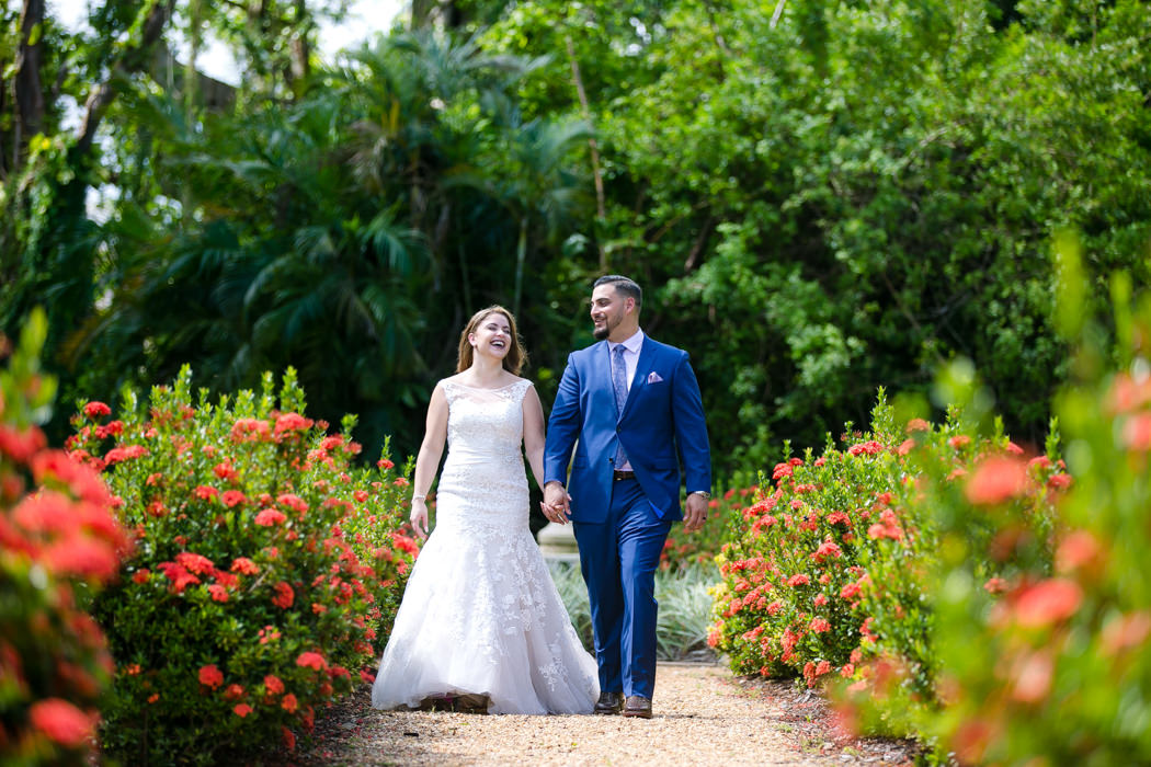 bride and groom walking through gardens of ancient spanish monastery