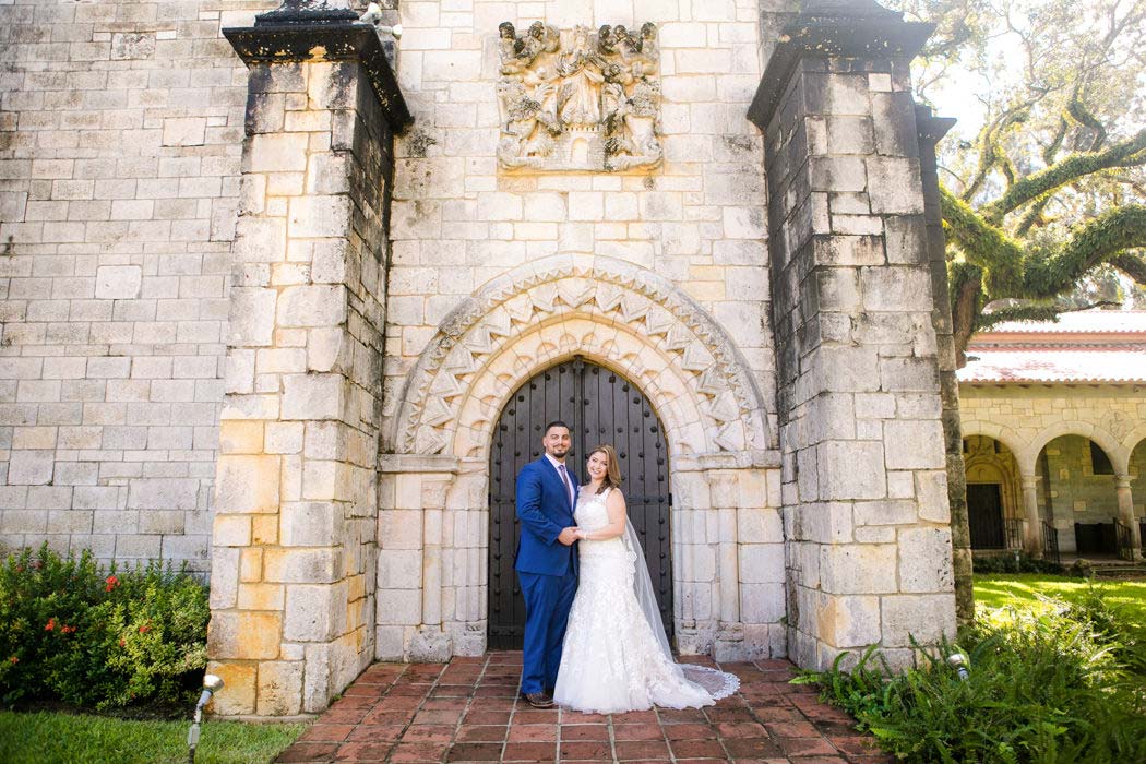 bride and groom pose at the doors of the ancient spanish monastery, miami