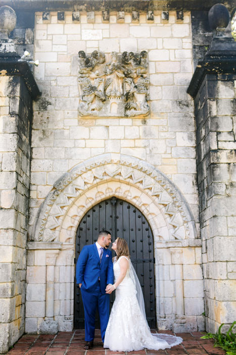 bride and groom at the door of the ancient spanish monastery in miami