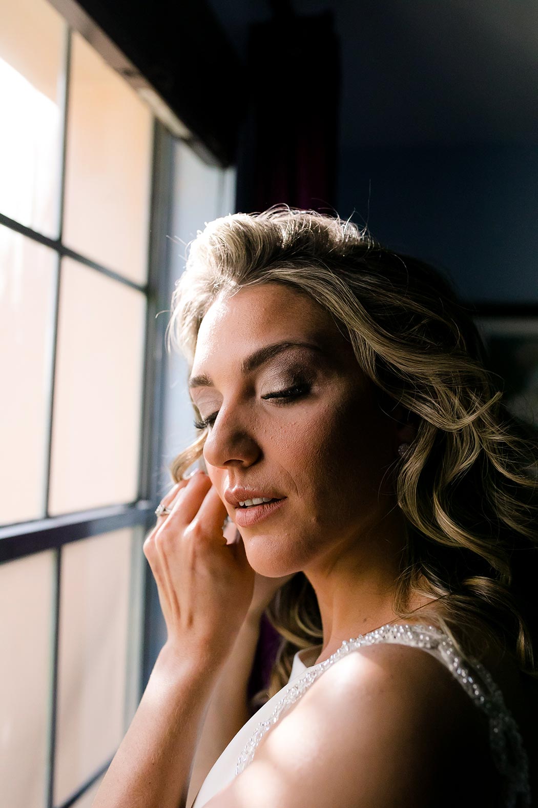 bride putting on her earrings before her wedding ceremony at the living sculpture sanctuary davie