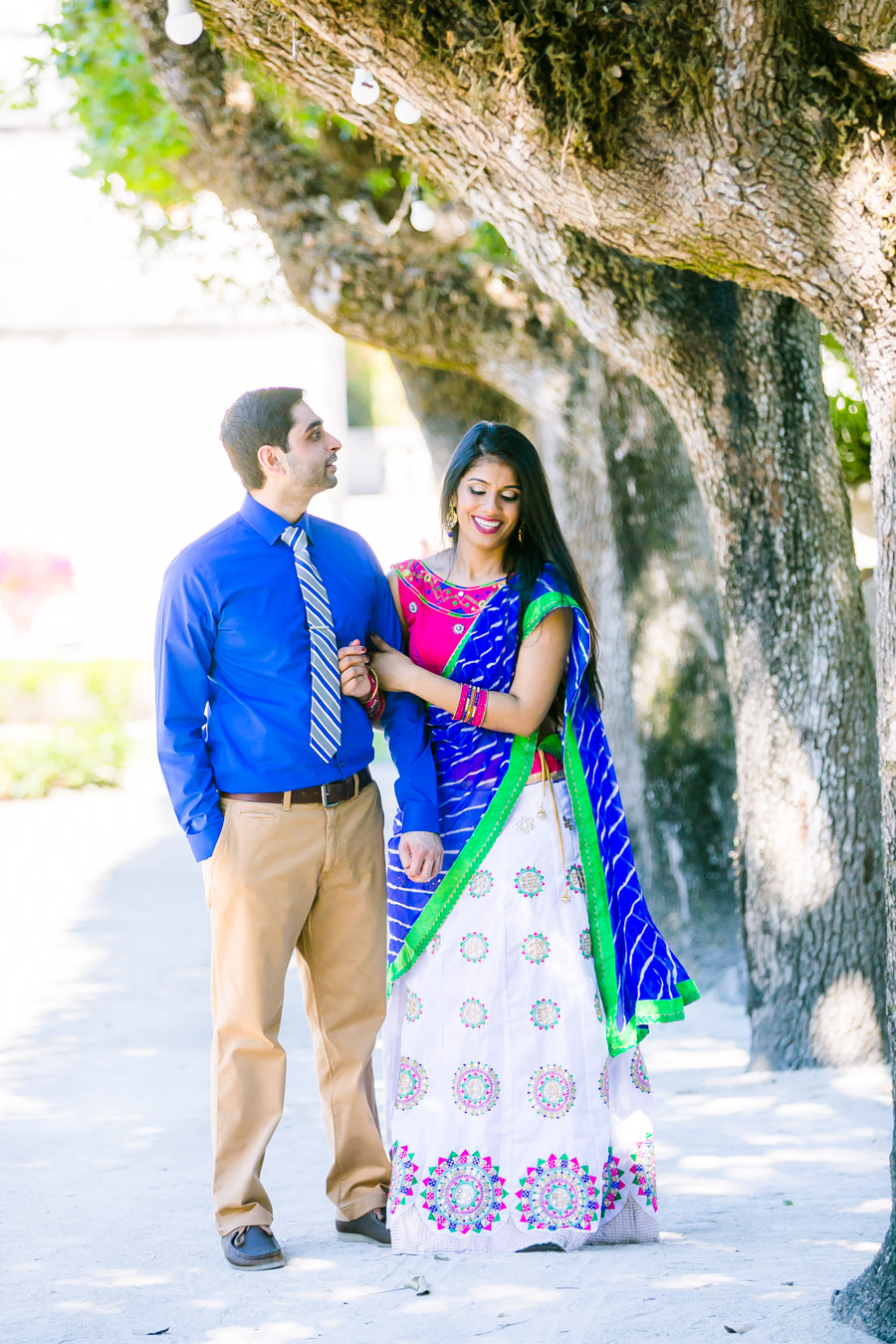 Indian couple laughing as they walk through vizcaya in miami on engagement photoshoot