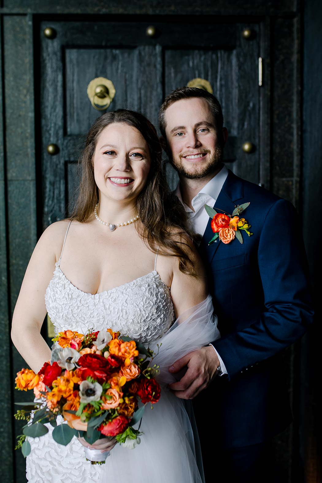 bride and groom portraits at east hotel miami with red and orange bouquet