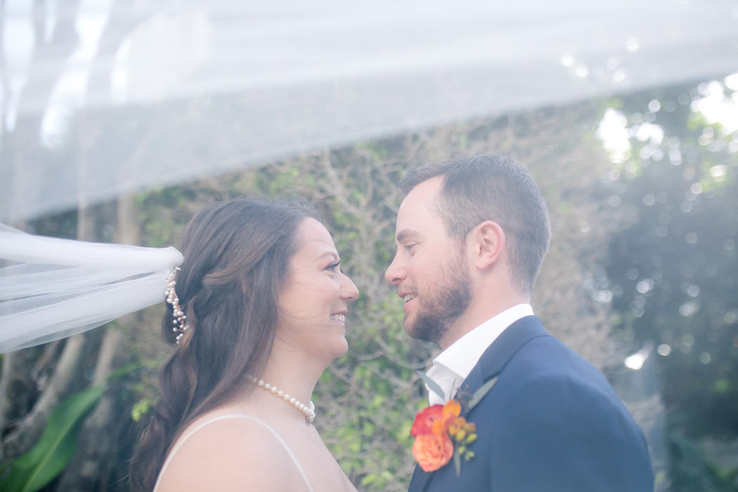 unique wedding shot with bride and groom and veil