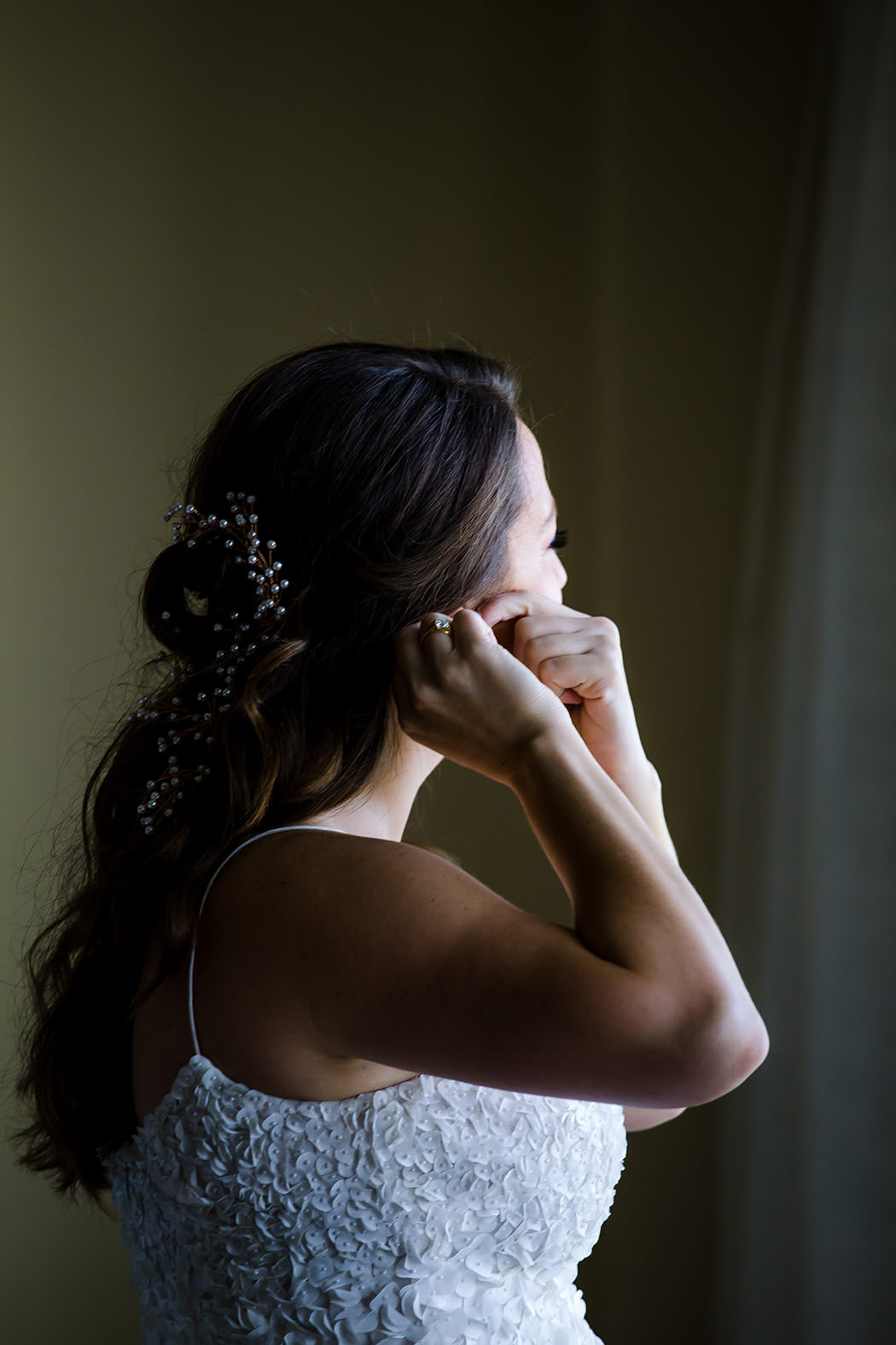 photograph of bride putting on earrings at modern Jewish wedding south florida
