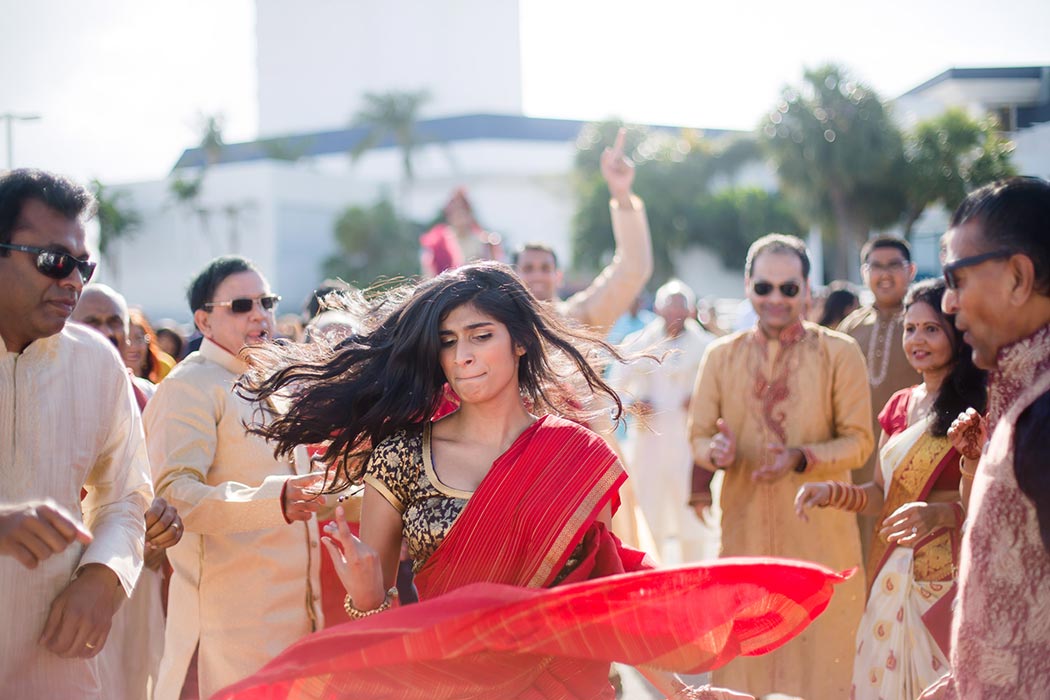 girl in red sari dances during south florida indian baraat celebrations