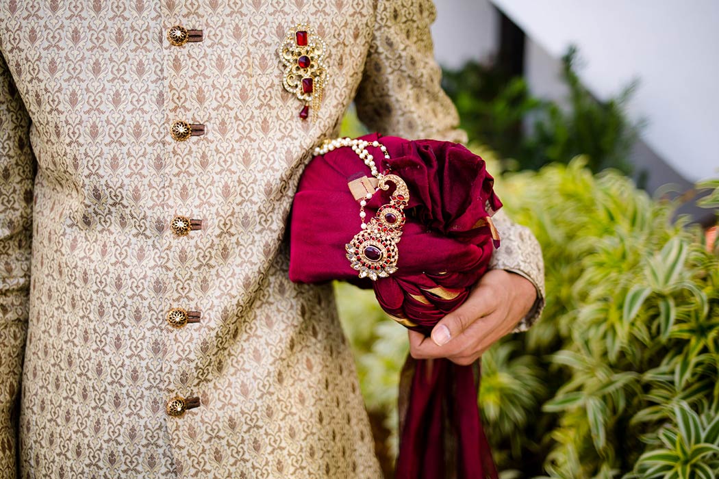 traditional indian groom poses in gold suit with red turban | fort lauderdale indian wedding photographer
