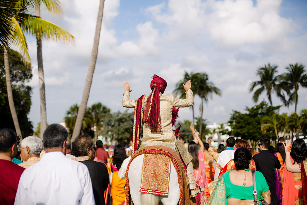 indian groom on white horse during baraat at bahia mar fort lauderdale