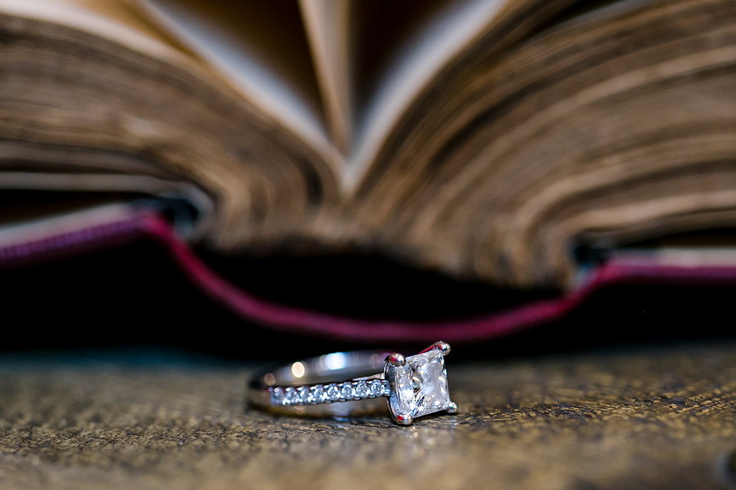 diamond engagement ring photographed next to antique book in engagement session