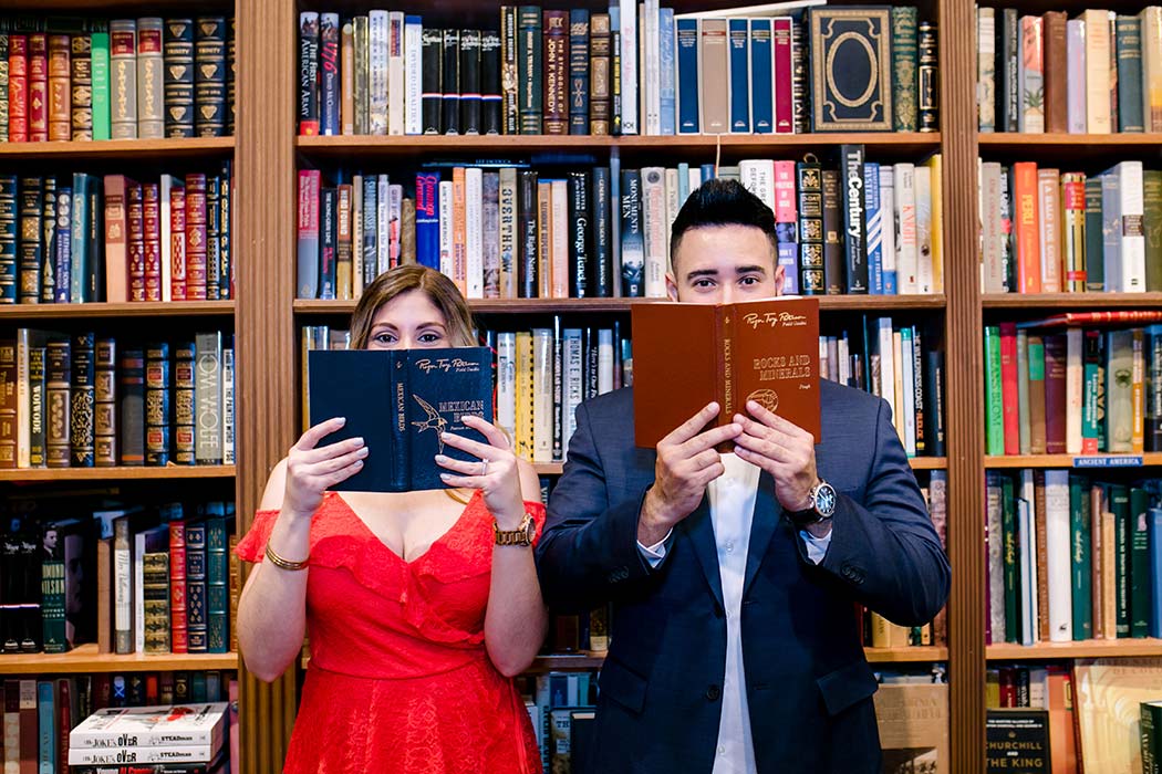 couple posing for their engagement session in an antique book shop