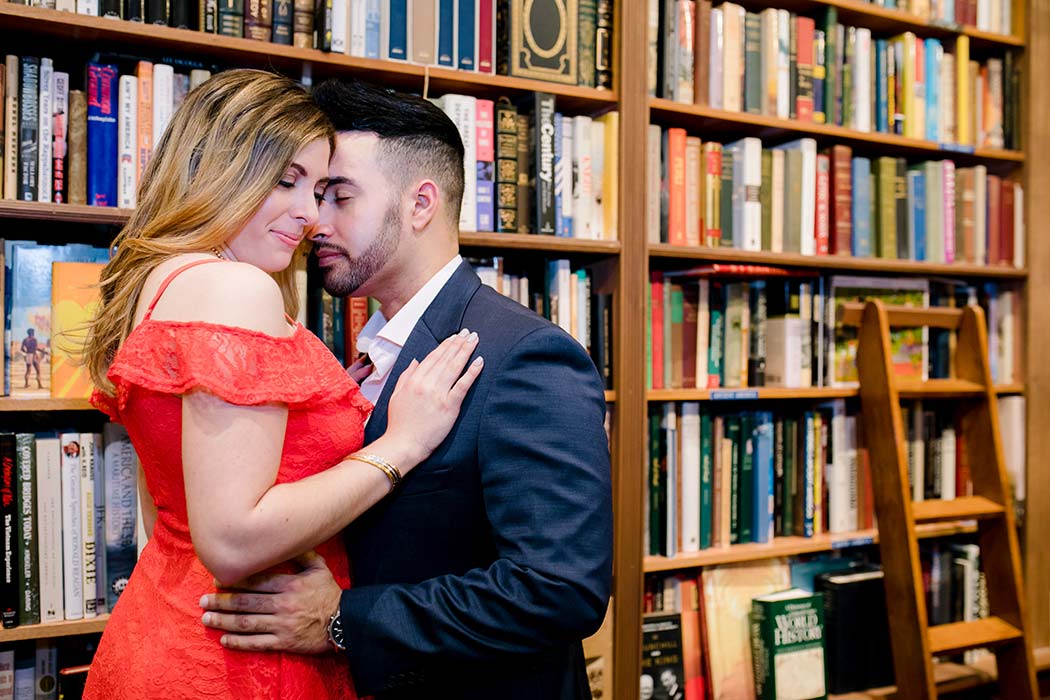 posing couple during an engagement session in book shop