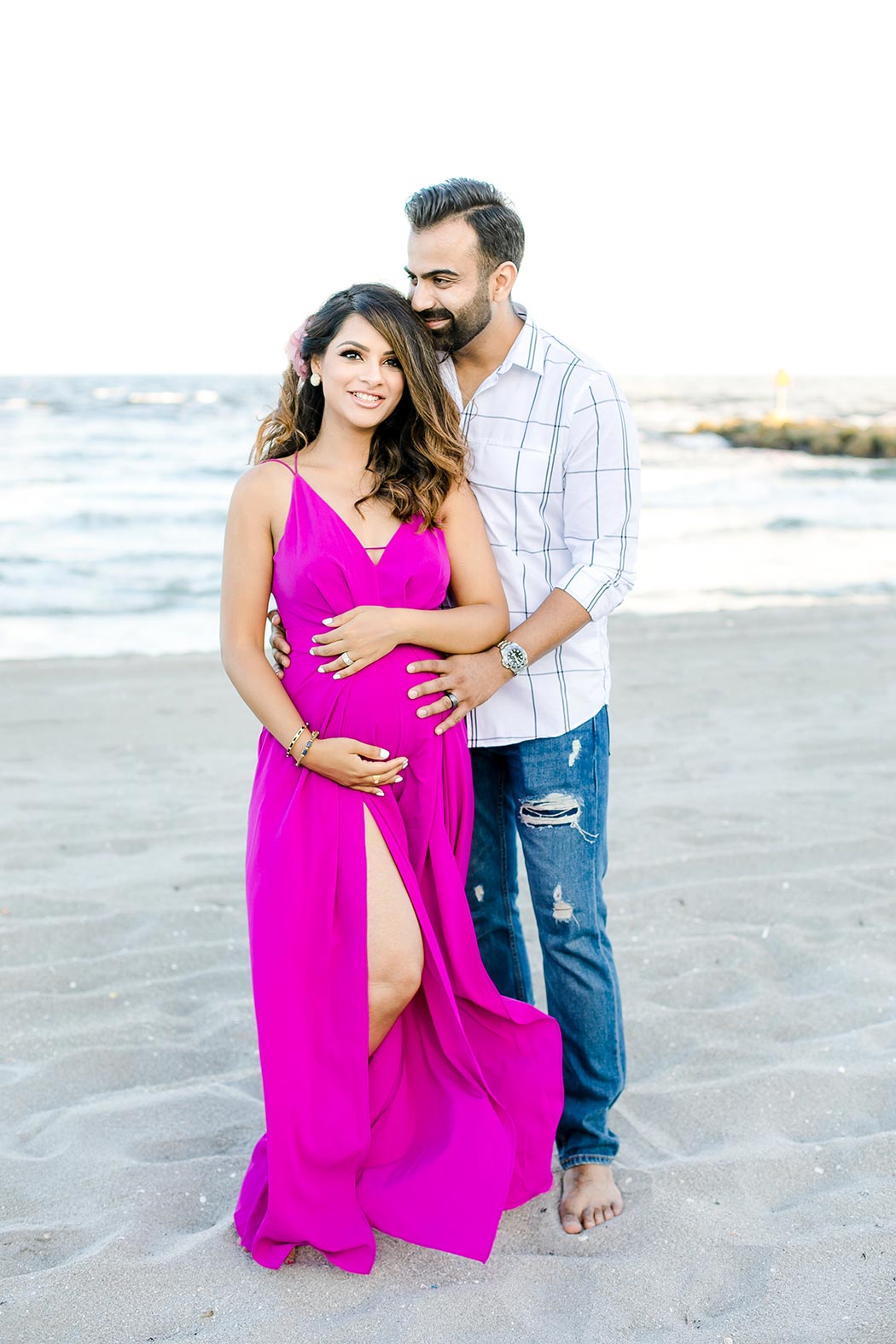couple pose for sunset beach maternity photography | pink maternity dress