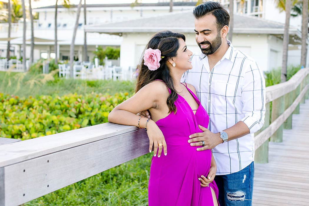couple posing on beach jetty for maternity photography in fort lauderdale