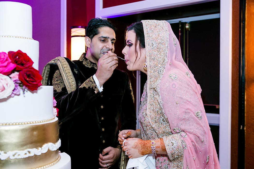 indian bride and groom portraits whilst eating their wedding cake