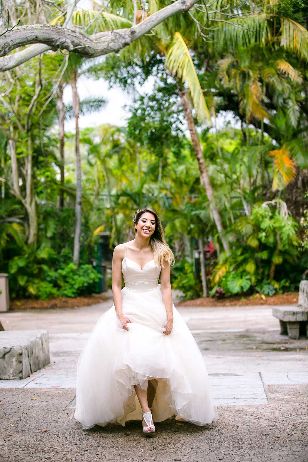 bride runs towards camera during unique bridal photographs at palm beach zoo wedding