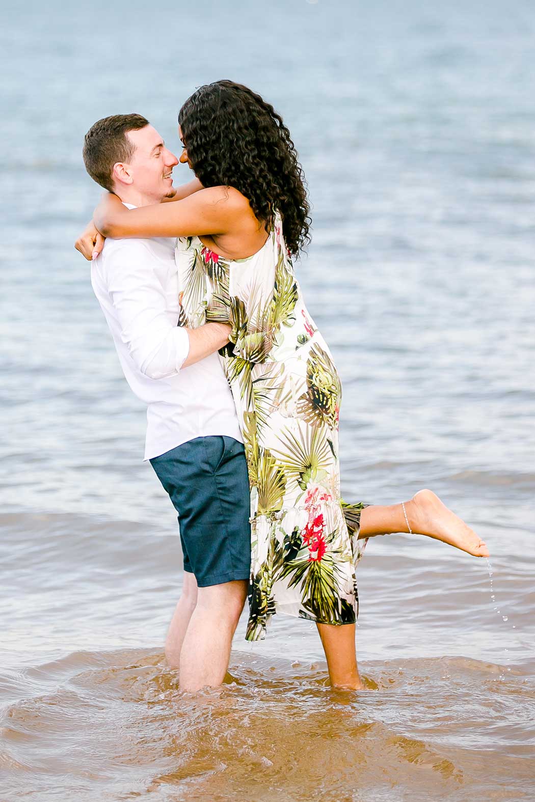 mixed race couple hug in water during engagement photography | pompano beach natural engagement photographer