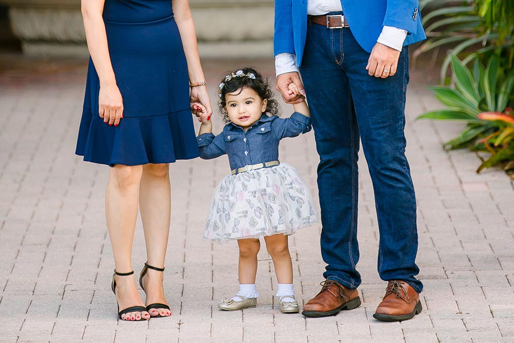 couple holding hand of young child during family photography session on las olas boulevard | fort lauderdale family photographer