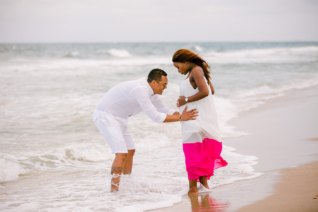 beautiful black couple posing in the sea during maternity photoshoot in south florida