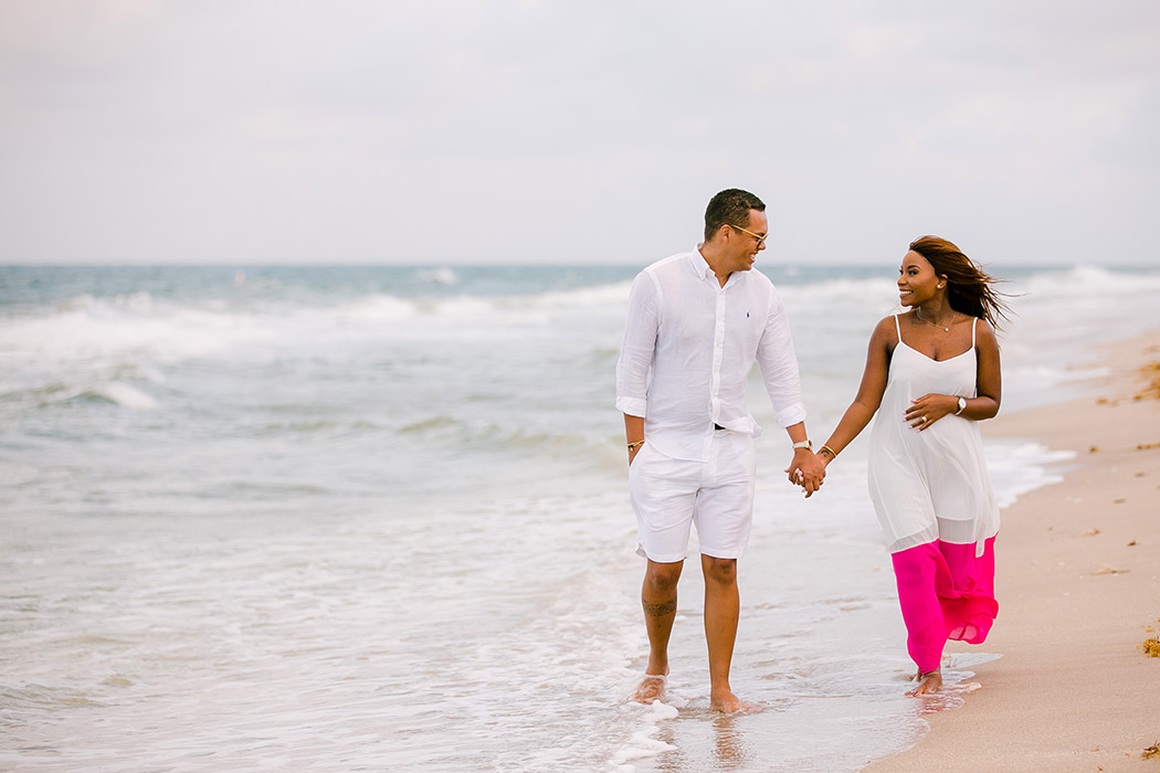 black couple walking on beach during maternity photoshoot on Pompano Beach